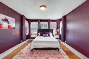 una camera da letto con un grande letto con pareti viola di 3 Bed 2 Bath by College Hill w Fitness Room a Wichita