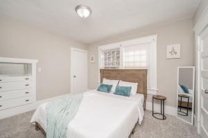 a white bedroom with a large bed with blue pillows at 4 Bed 2 Bath Home by College Hill and Hospitals in Wichita