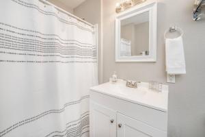 y baño blanco con lavabo y ducha. en 4 Bed 2 Bath Home by College Hill and Hospitals en Wichita