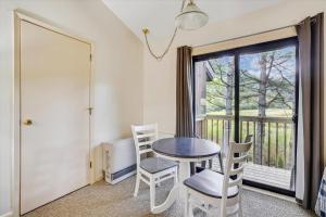 a dining room with a table and chairs and a window at Cedarbrook Standard Hotel Room 201 in Killington