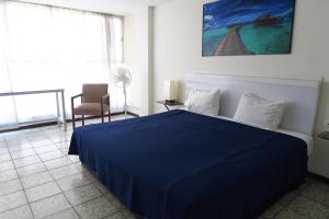 a bedroom with a blue bed and a chair at HOTEL LLANITO AGS in Aguascalientes