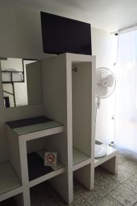 Un estante blanco con una TV encima. en HOTEL LLANITO AGS, en Aguascalientes