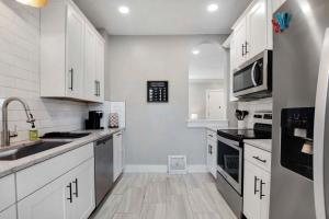una cucina con armadietti bianchi ed elettrodomestici in acciaio inossidabile di 2 Bed 1 Bath Property in College Hill with Garage a Wichita