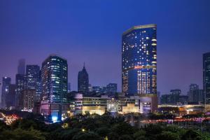 Guangzhou Marriott Hotel Tianhe في قوانغتشو: أفق المدينة في الليل مع المباني الطويلة