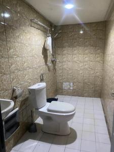 La salle de bains est pourvue de toilettes et d'un lavabo. dans l'établissement Sunrise Center Bonapriso, à Douala
