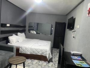 a hotel room with a bed and a mirror at Sunrise Center Bonapriso in Douala