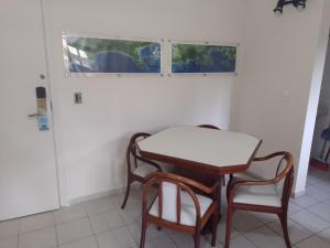 uma mesa e cadeiras num quarto com uma janela em Riviera Green Residence 232 em Bertioga