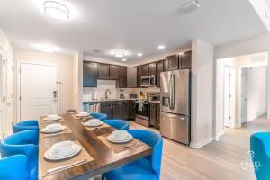 a kitchen and dining room with a table and blue chairs at TVPM-4001#107BD VC apts in Orlando