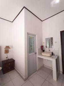 a white room with a door and a table and a mirror at Edu Hotel (Hotel Edukasi SMK PK) in Bangli