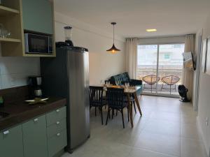 a kitchen and dining room with a table and a refrigerator at Bela Hospedagem - #Puerto Ventura 103A Beira Mar in João Pessoa