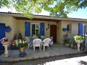 ClarensacにあるPretty house with private fenced poolの家の前のパティオ(椅子、テーブル付)