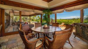 Mauna Lani Luxury Vacation Villas - CoralTree Residence Collection في وايكولوا: غرفة طعام خارجية مع طاولة وكراسي