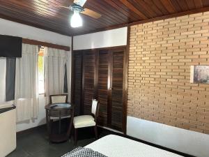 een slaapkamer met een bed en een tafel en een bakstenen muur bij West Water Park in Santo Antônio do Pinhal