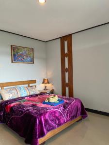 um quarto com uma cama com um cobertor roxo em Pondok Kembangsari em Bantang