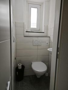 a small bathroom with a toilet and a window at Smart Appart in Cologne