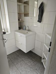 Baño blanco con lavabo y escalera en Smart Appart, en Colonia