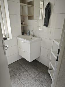 Biała łazienka z umywalką i drabiną w obiekcie Smart Appart w Kolonii