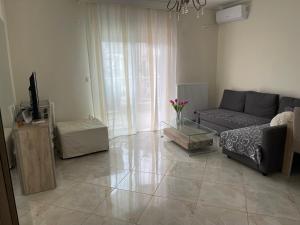 un soggiorno con un divano e una TV di Na’Vie Sunrise Apartment by the sea a Perea