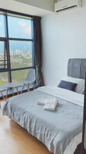 a bedroom with a bed with two chairs and a large window at High Rise Horizon City View Apt 4K Netflix in Johor Bahru