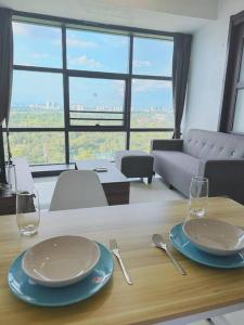 a table with two plates and glasses on top of it at High Rise Horizon City View Apt 4K Netflix in Johor Bahru