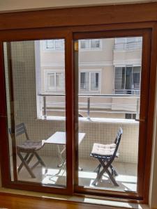 een raam met uitzicht op een tafel en een stoel bij Özçelik apartmanı in Alanya