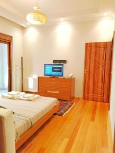 um quarto com uma cama e uma televisão numa cómoda em Özçelik apartmanı em Alanya
