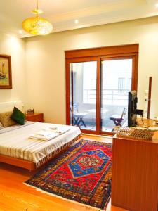 阿拉尼亞的住宿－Özçelik apartmanı，一间卧室配有一张床、一台电视和一张地毯。