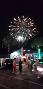 un espectáculo de fuegos artificiales con gente parada en un estacionamiento en 2 Bed 1 Bath Condo By Beach & Entertainment en South Padre Island