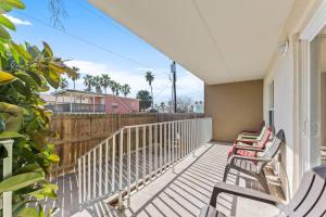 a porch with rocking chairs and a fence at 2 Bed 2 Bath 1st Floor Condo w Pool By Beach in South Padre Island