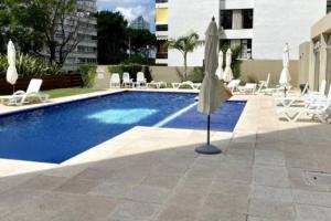 una piscina con sombrillas y sillas y una piscina en Moderno apartamento con Amenities, en Punta del Este