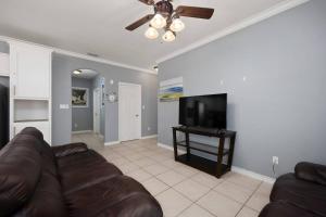 a living room with a couch and a flat screen tv at Luxury 3 Bed 2 Bath 2nd Floor Condo By Beach in South Padre Island