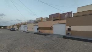 une rangée d'immeubles d'appartements dans une rue dans l'établissement Casa de 3 quartos a 2km da praia do aracagy ate 8 pessoas, à São Luís