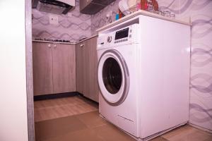 uma máquina de lavar roupa branca numa cozinha com em Maydec+ Apartment em Jidu