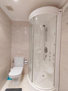 a white bathroom with a shower and a toilet at Nuevo Príncipe Centro Boutique in Vigo