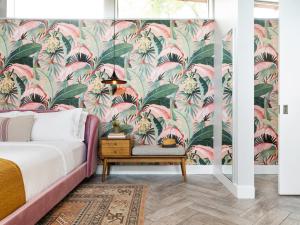 a bedroom with a pink and green floral wallpaper at ARRIVE Palm Springs - Adults Only in Palm Springs