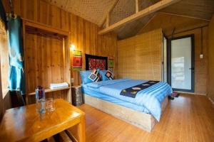 a bedroom with a bed and a table in it at Hong Thu Homestay & Bungalow in Quang Ba