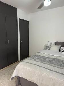 ein Schlafzimmer mit einem Bett und zwei schwarzen Schränken in der Unterkunft Cómodo Departamento en Providencia in Guadalajara