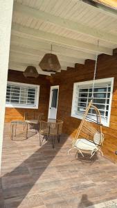 eine Veranda mit Stühlen und einer Schaukel auf einem Haus in der Unterkunft Buenas Vibras in Uribelarrea