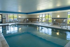 a large pool in a hotel with tables and chairs at TownePlace Suites Ann Arbor in Ann Arbor