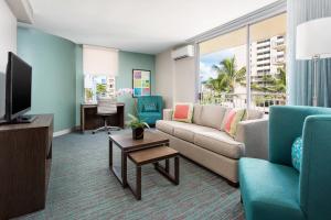 a living room with a couch and a tv at Courtyard by Marriott Waikiki Beach in Honolulu