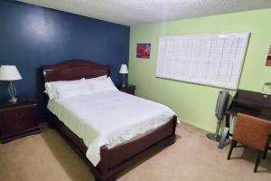 a bedroom with a bed and a desk and a window at Fully Furnished, Beautiful, Spacious Two Bedroom Condo in Lauderhill +26 photos