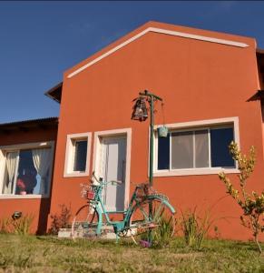Una bicicleta azul estacionada frente a una casa en Rincón del Sol en Gardey