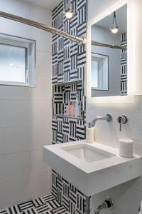 een witte badkamer met een wastafel en een spiegel bij ASH and KO in Phoenix