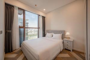 a bedroom with a white bed and a large window at Metropole Thu Thiem Condo Apartment in Ho Chi Minh City +141 photos