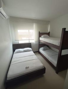 een kamer met 2 stapelbedden en een raam bij Cartagena Beach Apartment - Salida Directa Al Mar in Cartagena