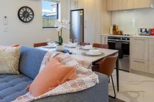a living room with a blue couch and a table at Beachside Bliss: 1 Bed 1 Bath in Christchurch