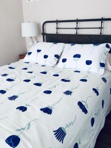 Bett mit blau-weißer Tagesdecke und Weingläsern darauf in der Unterkunft House on the Gwynns Falls in Baltimore