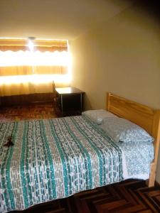 1 dormitorio con cama, escritorio y ventana en Nuevo Chez Julie 2, LA casa de Julie, en Arequipa