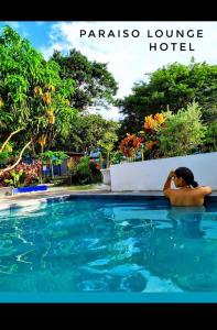 una mujer está sentada en una piscina en Paraiso Lounge, en Santa Marta