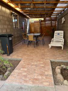 a patio with a table and chairs and a trash can at Rincon del Inca in San Pedro de Atacama